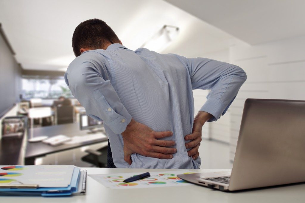 "Man suffering from back pain at the office