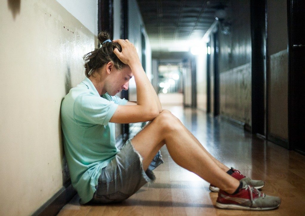Stressed teenager sitting in the hallway