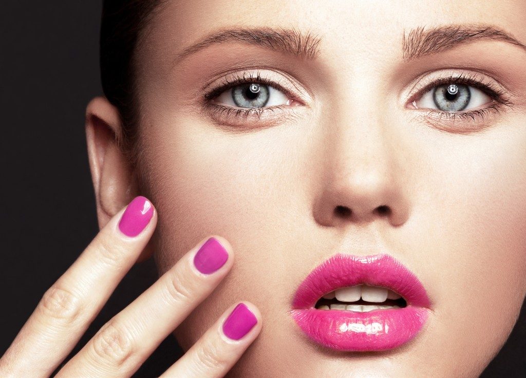 close up beauty shot of woman with pink lip and nails