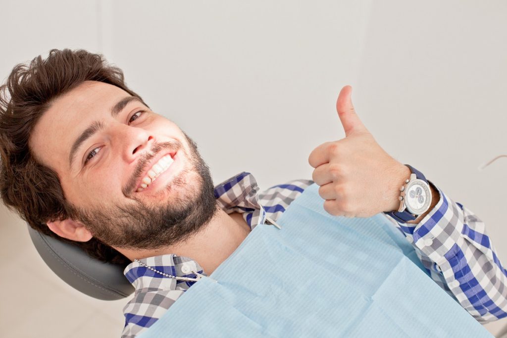 man giving a thumbs up at the dentist