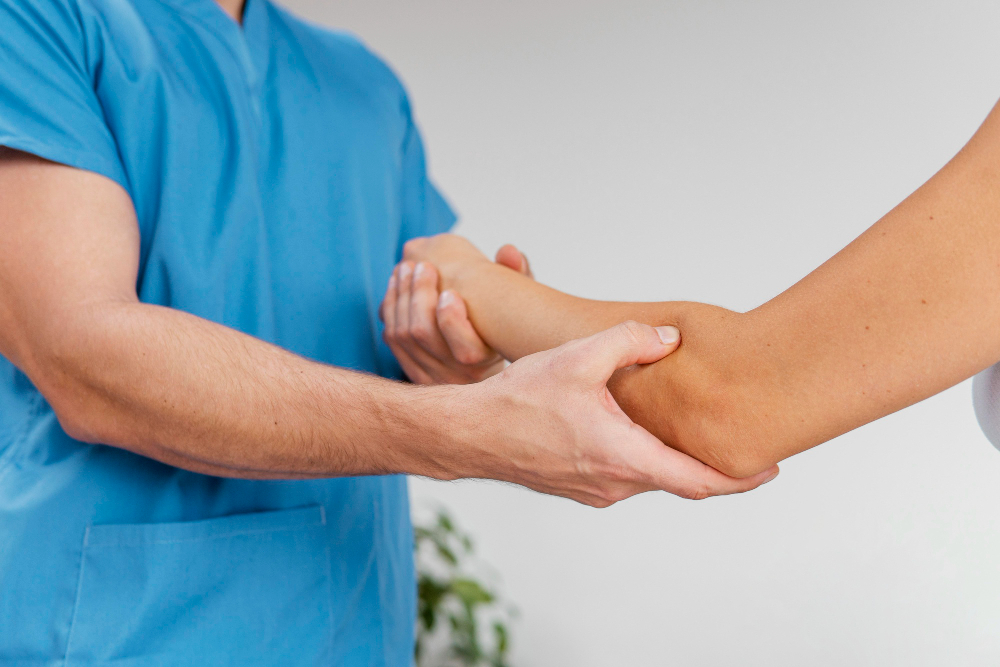therapist checking female patient's elbow joint movement