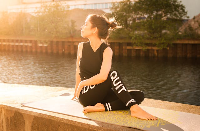woman Wearing Black Fitness Outfit Performs Yoga
